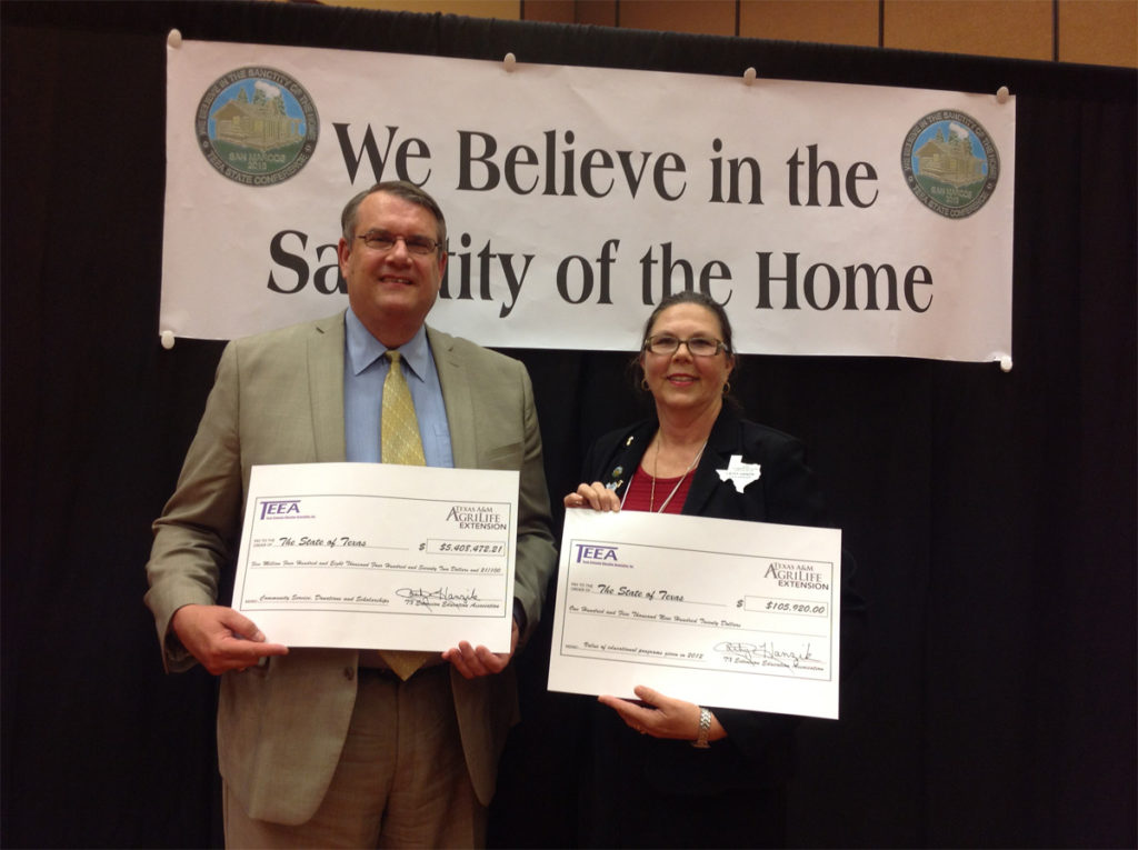 Cathy Hanzik, State TEEA President and Dr. Doug Steele, Texas A&M AgriLife Extension Service Director display TEEA's "Big Checks" showing the dollar value of TEEA's Educational Programs and TEEA's Honor Roll of Counties Volunteer Hours and Scholarship donations. These were presented at the 2013 TEEA State Conference in San Marcos, September 10.